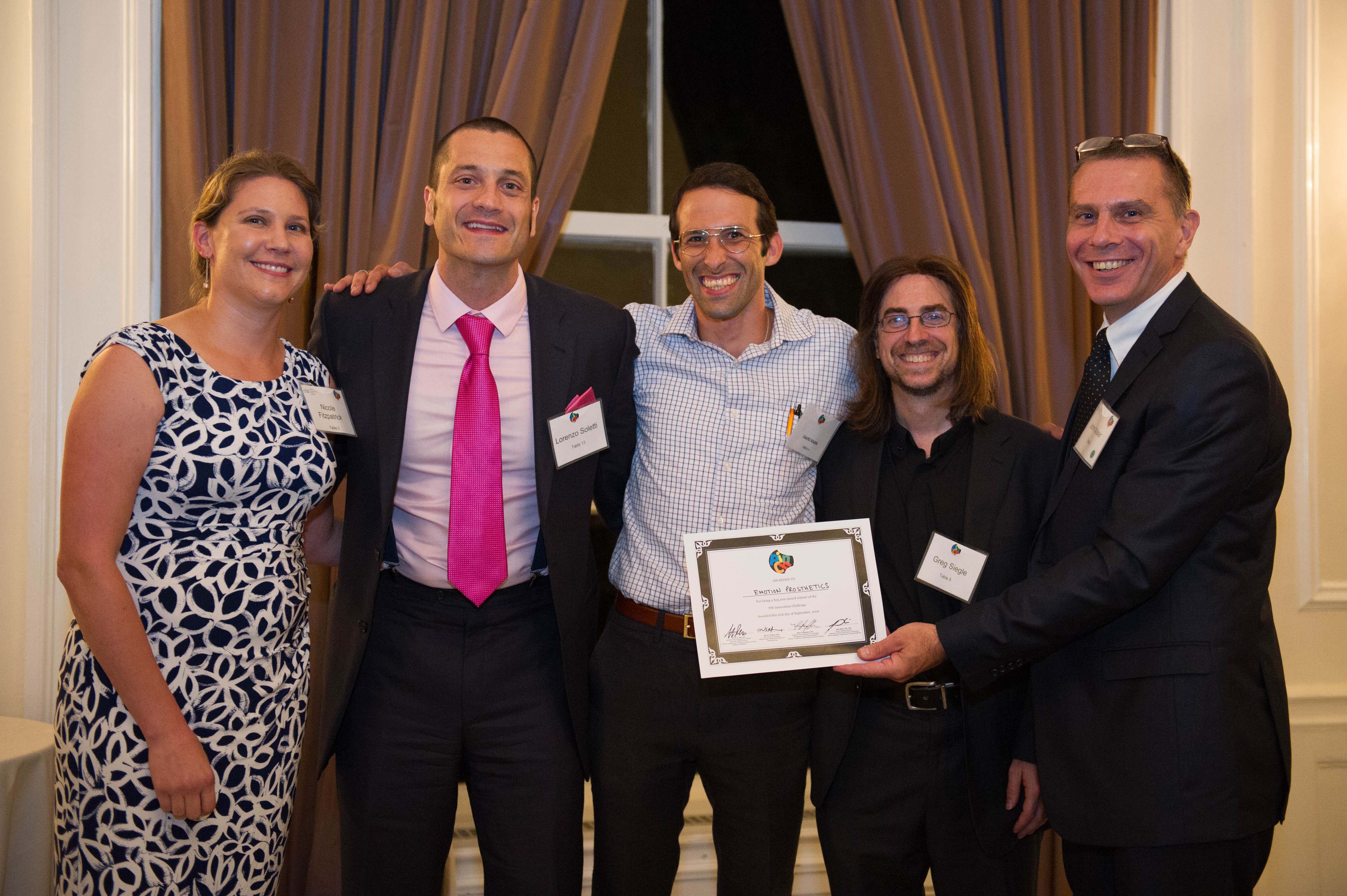 Emotion Prosthetics team holding award